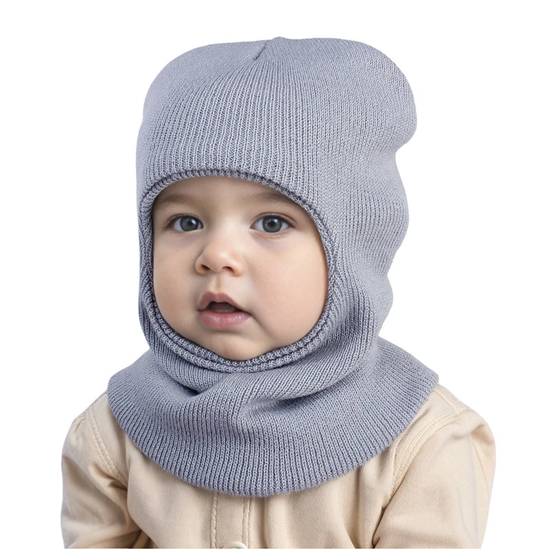 Cagoule Bébé Garçon Grise sur fond blanc legerement de profile porter par un bebe