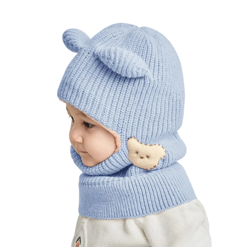 Cagoule Bébé Fille Bleue sur fond blanc porter par un bebe de profile