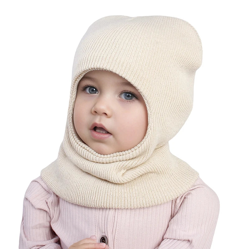 Cagoule Bébé Garçon Blanche sur fond blanc legerement de profile porter par un bebe