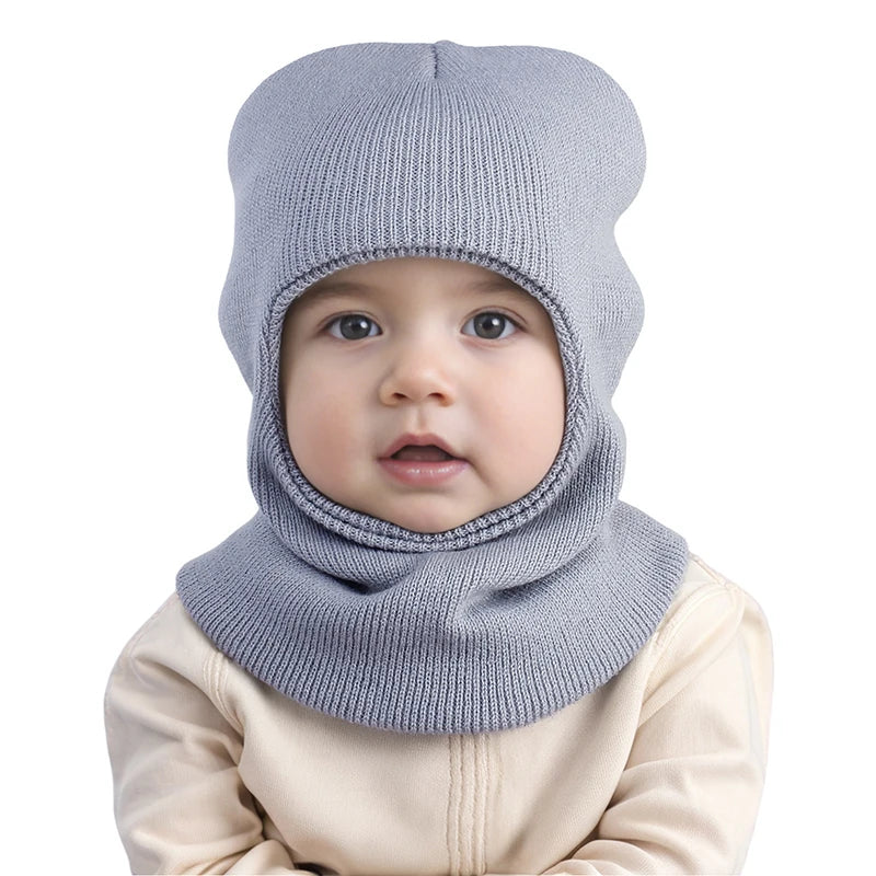 Cagoule Bébé Garçon Grise sur fond blanc porter par un bebe